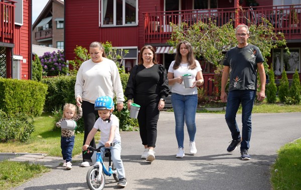 En familie med voksne og barn er ute og går med bøsse.