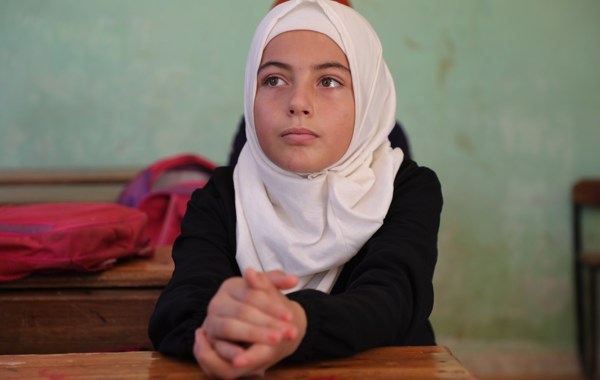 Ung jente i hijab ser lengtende bort.