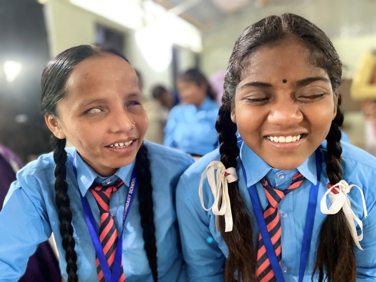 To smilende blinde jenter fra Nepal